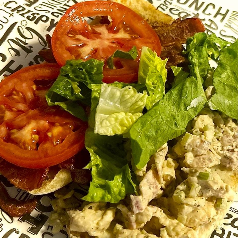 Close-up of a Grinders Soups and Subs sandwich with chicken salad, bacon, lettuce, and tomato.